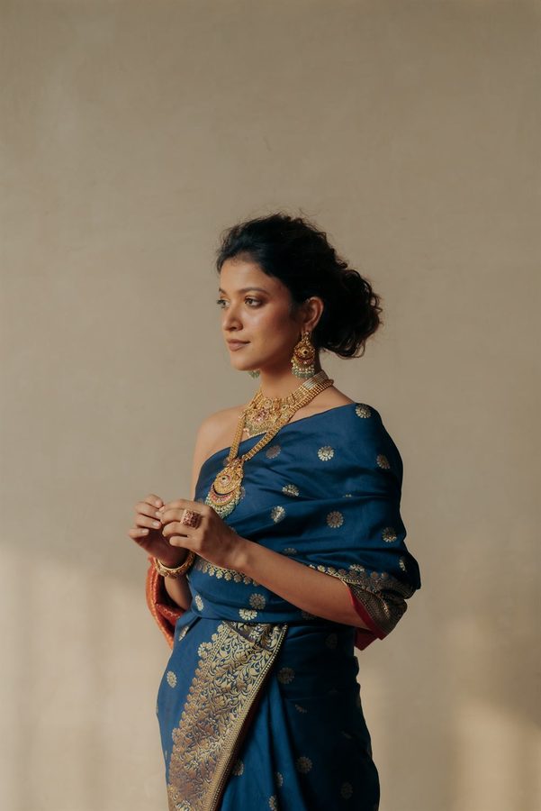 Model in a blue silk saree wearing an antique gold necklace