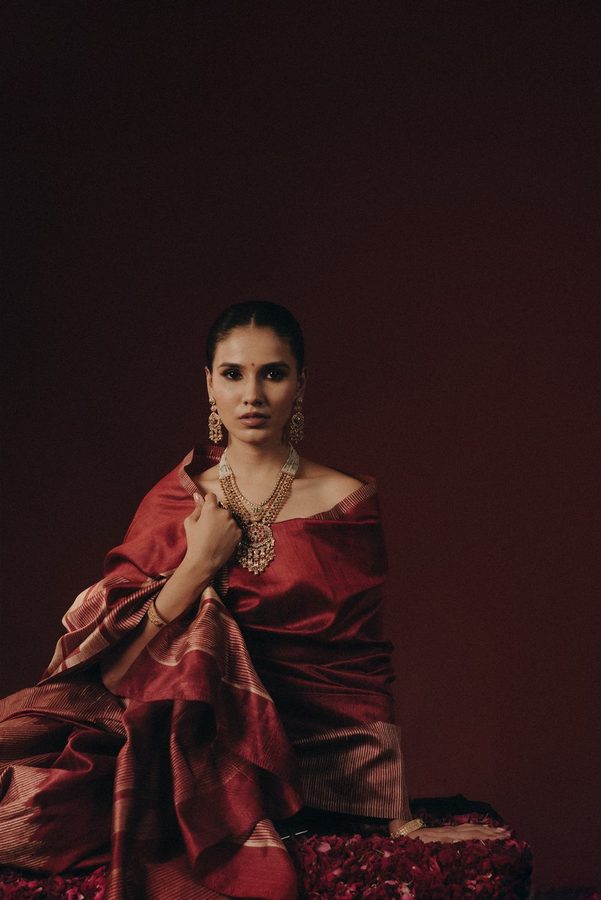 Model in maroon silk wearing antique gold jewellery
