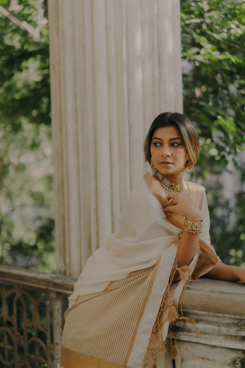 Model in an ivory silk saree wearing antique gold jewellery